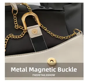 Detailed close-up of the elegant gold chain strap and magnetic snap closure on the bag