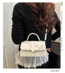 Cream white handbag with crossbody strap shown on a model for scale and fit