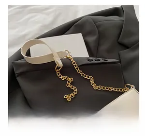 Detail of off-white shoulder bag with elegant leather and gold chain patchwork strap