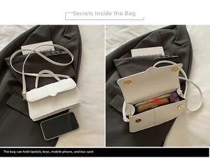 Detail view of white leather handbag interior showing storage capacity for essentials