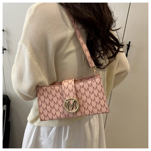 Close-up of pink underarm bag with all-over M letter print and gold circular metal buckle