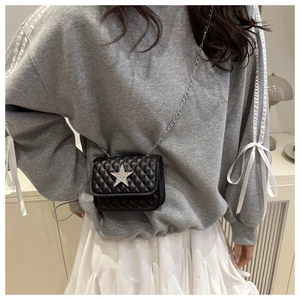 Detail of black quilted crossbody bag with sparkling silver star rhinestone and chain strap