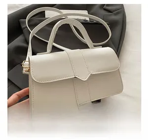 Detailed view of white leather baguette bag with V-flap and vertical embossed lines