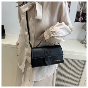Dettaglio di una borsa a tracolla vintage in pelle nera con testo FASHION&BAG