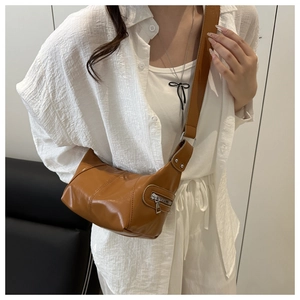 Detail of caramel crescent crossbody bag with adjustable strap and silver zipper pocket