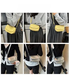 Close-up of minimalist crossbody saddle bags in silver and yellow with adjustable straps