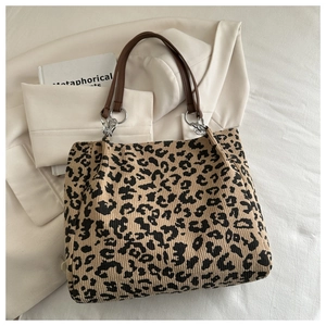 Detailed shot of leopard print corduroy tote bag with leather straps and silver rings