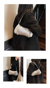 Detailed close-up of metallic silver baguette bag with micro-wrinkle texture and buckle strap