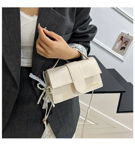 Detail of cream flap crossbody bag with pearl lace bow and Fashion letter print