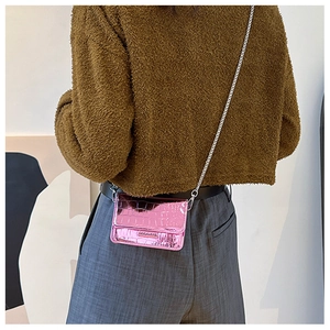 Close-up detail of a stylish mini pink metallic crocodile pattern crossbody bag worn on back