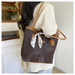 Detail of snake embossed tote bag with elegant silk scarf and slender shoulder strap