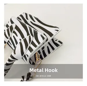 Close-up of zebra pattern handbag with metal hooks and lychee grain texture