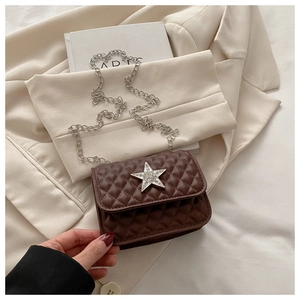 Detail of dark brown quilted crossbody bag with rhinestone star buckle and silver chain