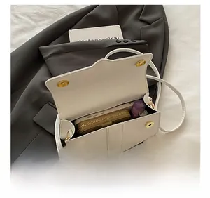 Interior view of the white shoulder bag showing capacity for phone and cosmetics