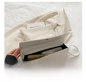 Interior view showing capacity of white crocodile embossed baguette bag with a phone