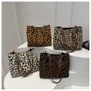 Detailed overhead view of leopard print corduroy tote bags with metal chain straps