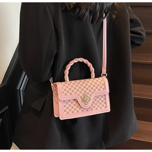 Detail of pink monogram handbag with floral metal lock and twisted handle on black blazer
