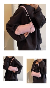 Detail of pink patent leather baguette bag with silver buckles and zipper closure