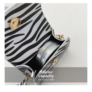 Internal capacity of zebra print mini crossbody bag showing golden magnetic buckle