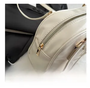 Close-up of smooth light gold metal zipper on white leather bag with black suit background