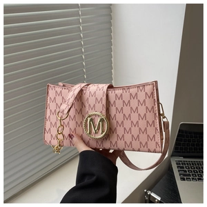 Detailed macro view of pink handbag featuring vintage M-monogram and gold metal buckle