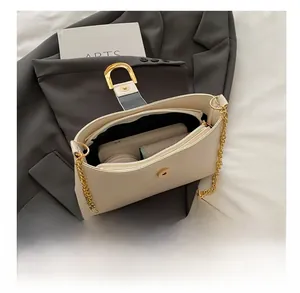 Macro shot showing internal capacity of minimalist off-white shoulder bag with golden hardware