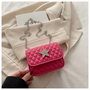 Close-up of quilted fuchsia crossbody bag featuring a silver rhinestone star buckle