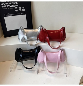 Detailed display of glossy patent leather baguette bags in silver, red, black, and pink colors