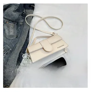 Detail view of cream-white crossbody bag with pearl pendant and fashion print on fabric
