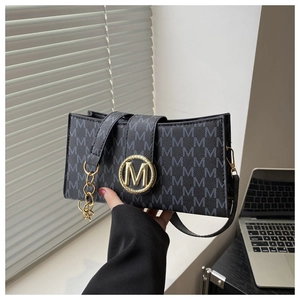 Close-up of gray monogram shoulder bag with gold M buckle and fine leather texture