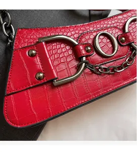 Detail of red crocodile texture bag with vintage metal D-ring and chain hardware