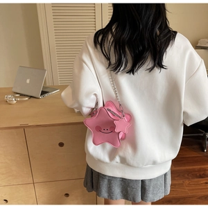 Detailed view of pink star-shaped crossbody bag with metal chain strap and smiling face
