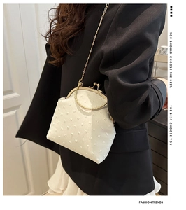 Detalle del bolso bandolera blanco con textura de puntos 3D y cierre de beso dorado