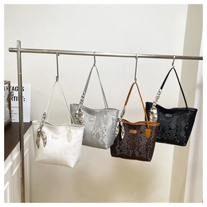Detail view of large tote bags with snake pattern embossing and silk scarves in four colors