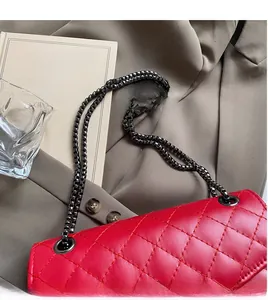 Vue de dessus d'un sac bandoulière en cuir matelassé rouge avec chaîne en métal foncé chic
