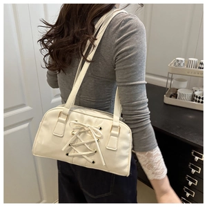 Detail of cream bow-knot shoulder bag with lace-up corset design and gold eyelets
