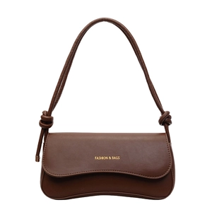 Dark brown leather baguette shoulder bag with wave edge flap and gold fashion text
