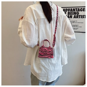 Mini pink zebra print crossbody bag shown on a model for size and style reference
