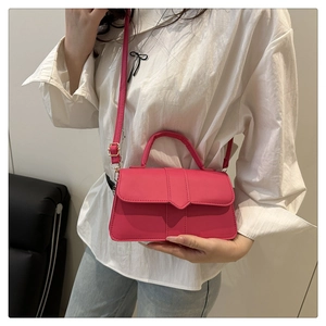 Pink lychee texture crossbody bag with adjustable strap worn on a white top