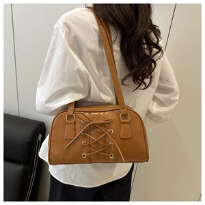 Close-up of caramel brown shoulder bag with lace-up detail and corset-style design