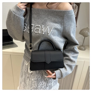 Minimalist black leather crossbody bag featured in a casual lifestyle setting