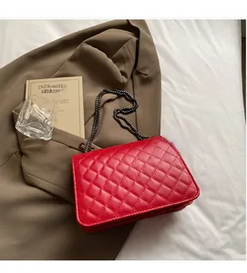 Détail d'un sac à main en cuir matelassé rouge avec bandoulière chaîne noire