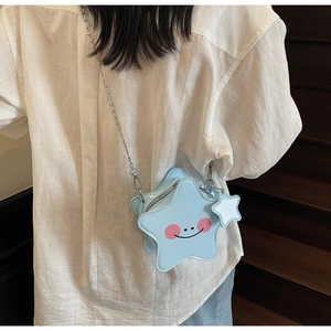 Detail of light blue star-shaped crossbody bag with smiley face and silver chain strap