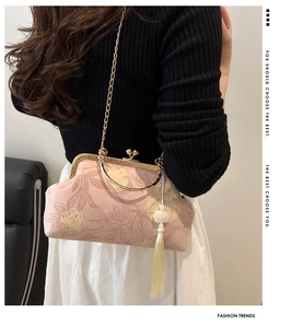 Pale pink shell bag with floral texture and vintage metal clasp worn by a model