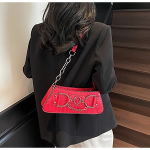 Red crocodile pattern underarm bag with silver chain worn by a model in a black blazer