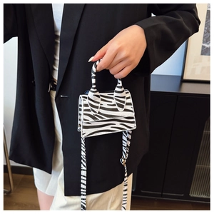 Detail shot of the zebra pattern mini handbag with adjustable strap and silver buckle