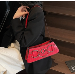 Detail of red croc-effect underarm bag with silver chain and metal ring accents