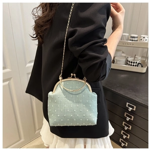 Détail du sac bandoulière en tissu vert menthe à pois 3D et fermoir doré chic