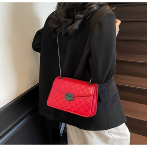 Détail du sac à bandoulière matelassé rouge avec serrure en métal noir et couches internes