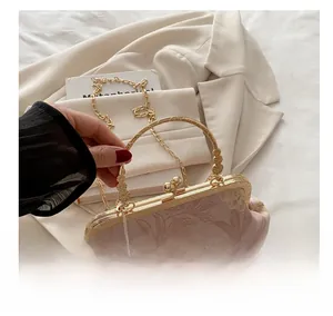Detail of floral embroidery on vintage shell bag with gold handle and chain strap